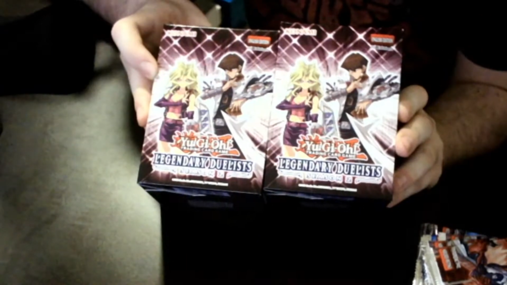 A man holds two boxes of trading cards