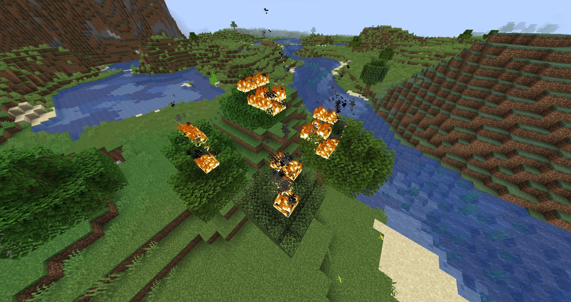 Screenshot of fire in Minecraft. A heavily stylized, pixelated block rendering of an outdoors environment with a river and several hills and cliffs. A cluster of trees in the center of the view is caught on fire.