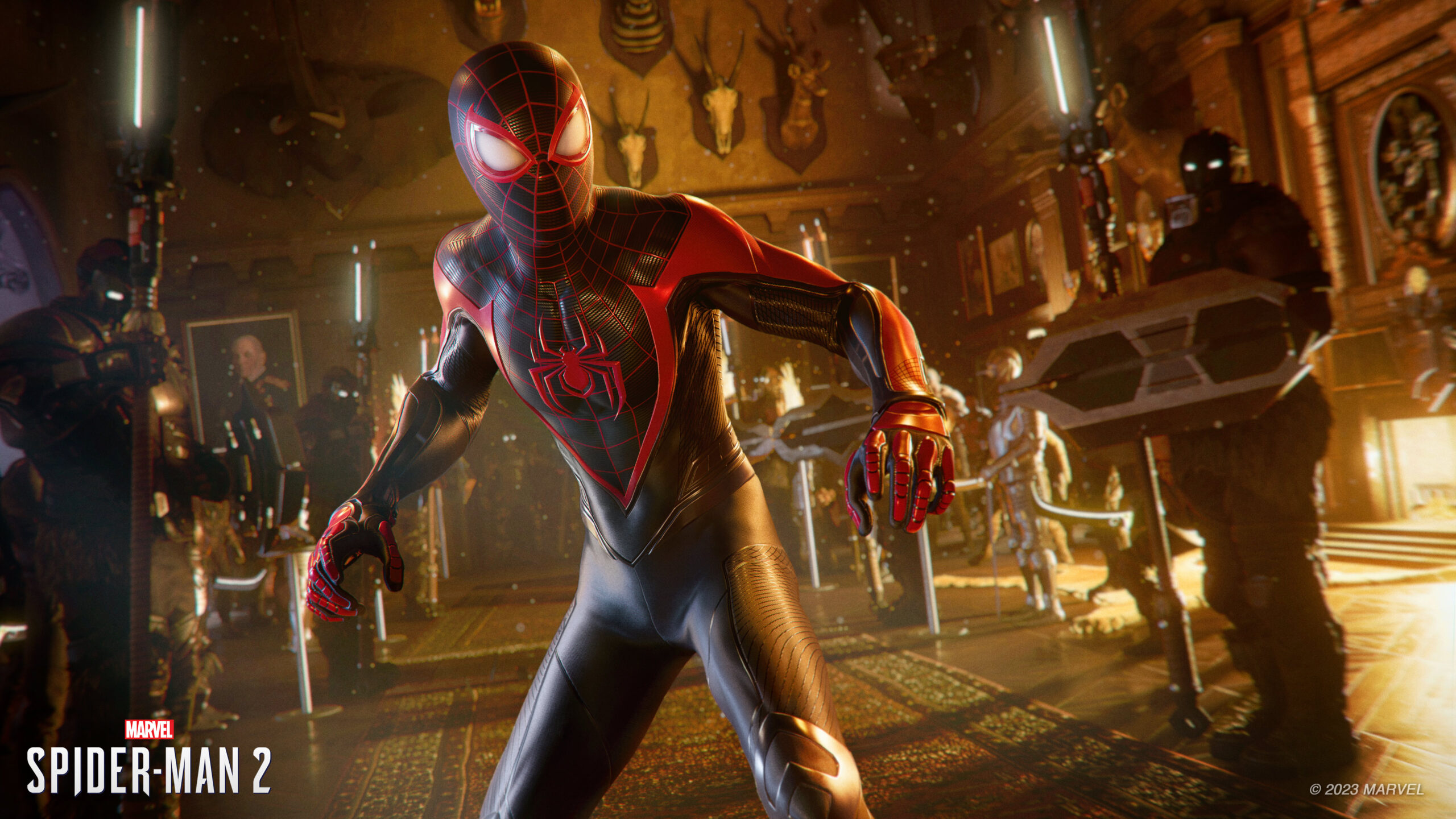 Press screenshot from Marvel's Spider-Man 2. A young man donning a head-to-toe suit with spider iconography stands in the middle of a museum exhibit, surrounded by heavily armed and geared figures.