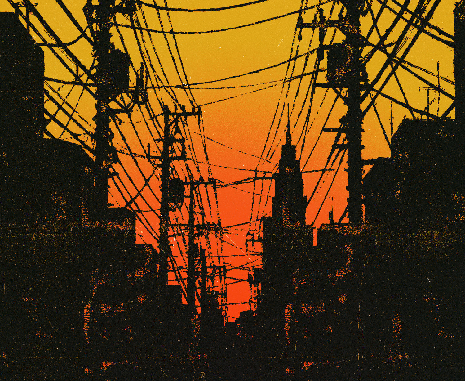 The power lines and buildings of a city silhouetted against a low sun.