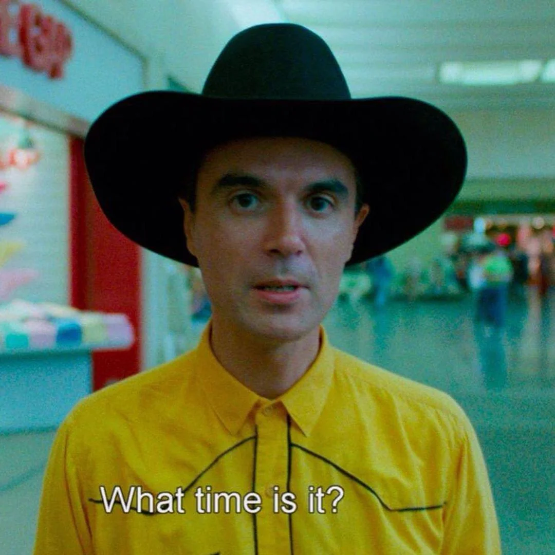 David Byrne, wearing a cowboy hat, stares at the camera.